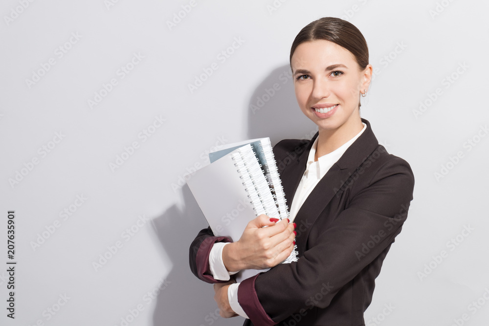 Young smiling businesswoman holding books in her hands. Fashion style photoshoot with har light source Young smiling businesswoman holding books in her hands. Fashion style photoshoot with har light source