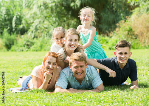 Smiling man and woman with kids lying in park