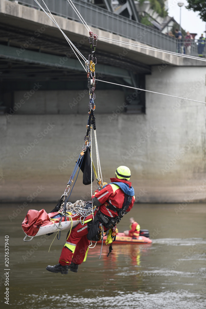 Fototapeta premium Feuerwehr Bergung Abseilen über Fluss