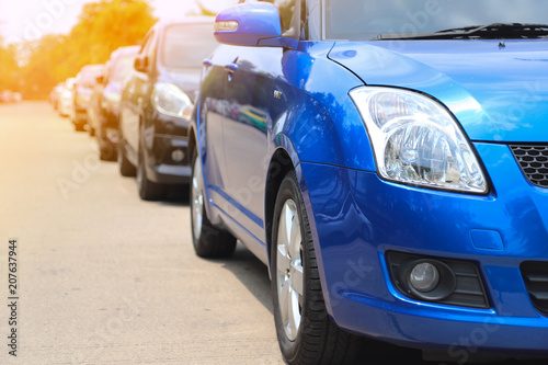 Closeup of front side of blue car parking beside the street.