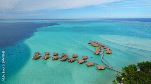 Aerial view of Motu Tautau, palm trees on little islets and turquoise water of blue lagoon, over water bungalows, tropical paradise of South Pacific Ocean - Tahaa island, seascape of French Polynesia photo