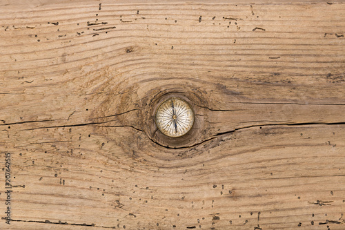 Old vintage compass on cracked wood plank