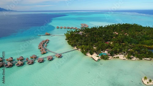 Aerial view of Motu Tautau, palm trees on little islets and turquoise water of blue lagoon, over water bungalows, tropical paradise of South Pacific Ocean - Tahaa island, seascape of French Polynesia photo