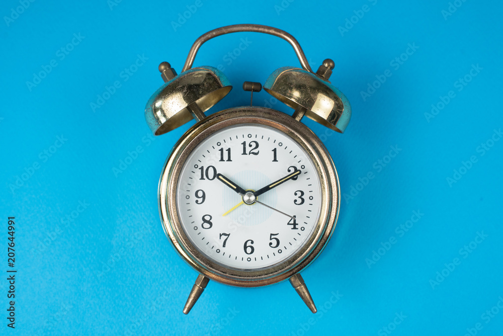 Golden bell alarm clock isolated on blue background. time concept Golden bell alarm clock isolated on blue background. time concept
