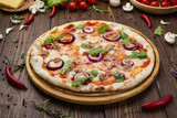 Minced meat tomato red onion pizza on a wood background
