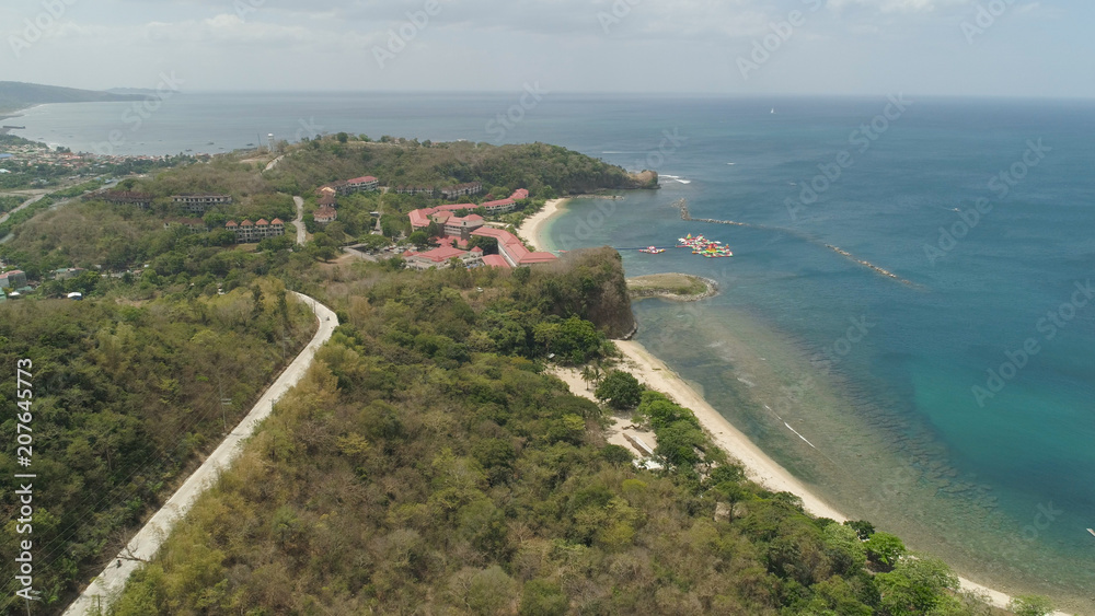 Aerial view of coast with beach, hotels. Philippines, Luzon. Coast ocean with tropical beach, turquoise water. Tropical landscape in Asia.