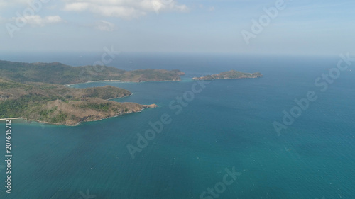Aerial view of coast with beaches, island Limbones, lagoons and coral reefs. Neela cove, Philippines, Luzon. Coast ocean with turquoise water. Tropical landscape in Asia.