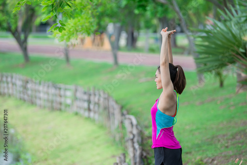 Asian sporty woman stretching body breathing fresh air in the park,Thailand people,Fitness and  exercise concept,Jogging in the park © reewungjunerr