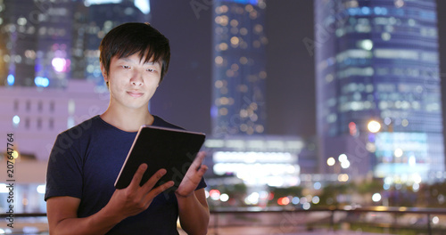 Photography Asian Man use of tablet computer at night