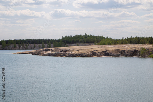 Fototapeta Naklejka Na Ścianę i Meble -  Flooded open pit quarry ore clay mining with blue water