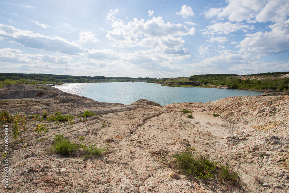 Flooded open pit quarry lake ore clay mining with blue water Flooded open pit quarry lake ore clay mining with blue water