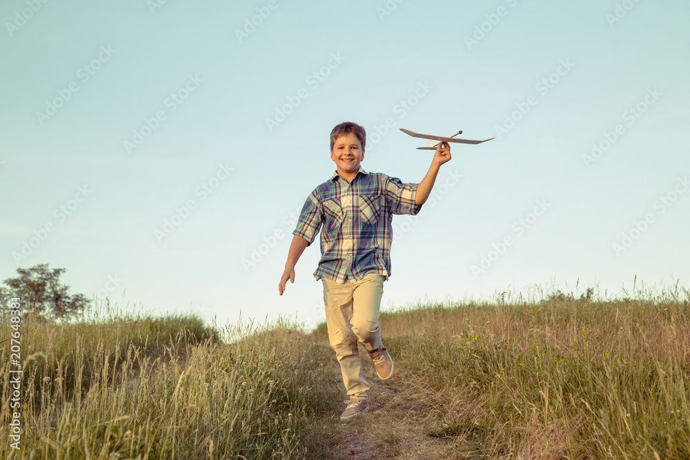 boy running with his airplane at green field boy running with his airplane at green field