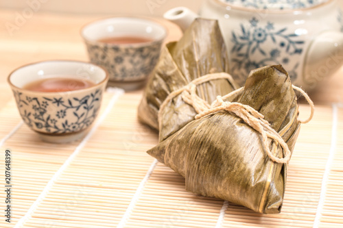 Zongzi - Traditional Dragon Boat Festival dumpling. Hand drawn watercolor painting isolated on wood background.