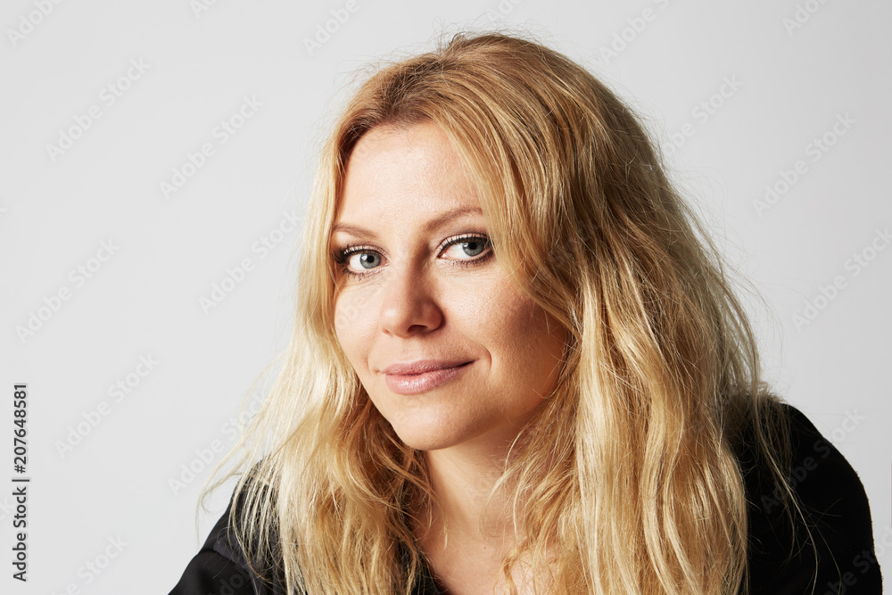Pretty adorable woman with pleasant smile looks directly into camera, isolated over gray background. Smiling friendly young female rejoices her success. Pretty adorable woman with pleasant smile looks directly into camera, isolated over gray background. Smiling friendly young female rejoices her success.