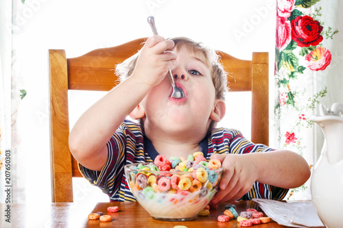 Boy eating colorful breakfast cereal photo