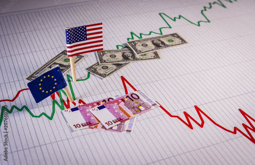 Φωτογραφία Flags and coins of the EU and the USA over a graph that symbolizes the fluctuations of the exchange rate of the currency and the appreciation of the dollar against the euro