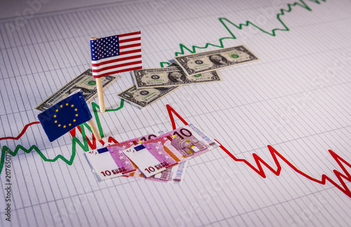 Foto Flags and coins of the EU and the USA over a graph that symbolizes the fluctuations of the exchange rate of the currency and the appreciation of the dollar against the euro
