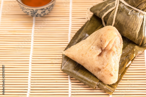 Zongzi - Traditional Dragon Boat Festival dumpling. Hand drawn watercolor painting isolated on wood background.