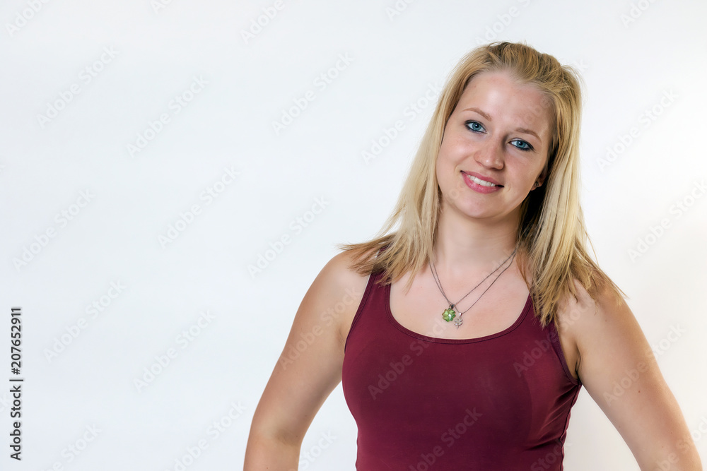 Studio shot of the attractive young blond woman posing in sportswear. The woman is smiling at the camera. Studio shot of the attractive young blond woman posing in sportswear. The woman is smiling at the camera.