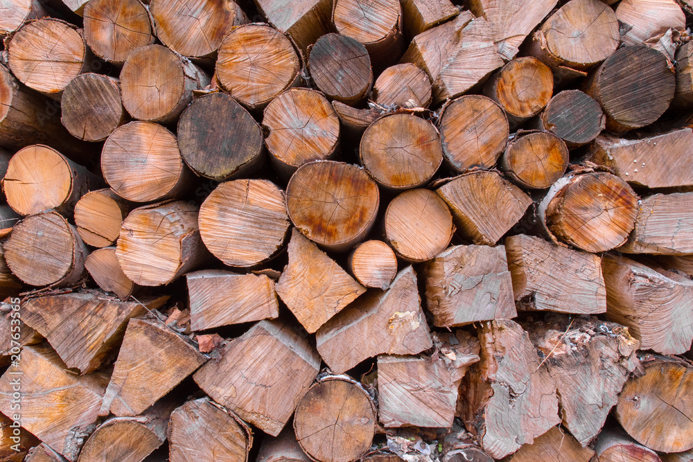 A stack of wooden logs sits awaiting use as firewood A stack of wooden logs sits awaiting use as firewood