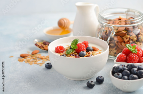 Homemade granola with yogurt and fresh berries, healthy breakfast concept, selective focus.