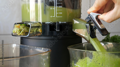 Fotografia Process of extracting fresh juice from apple and mint