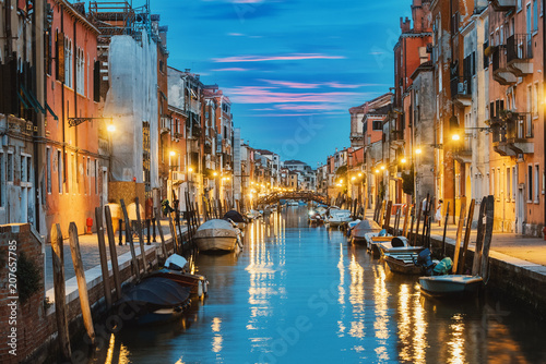 Water canal and colorful historic houses at night in Venice, Italy © agcreativelab