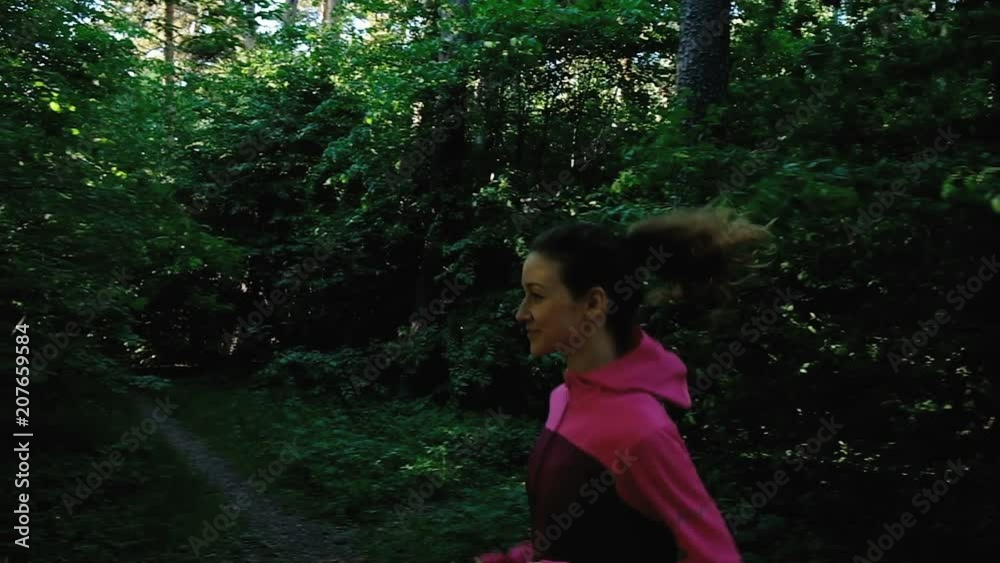 Young girl runs in the forest, a woman is running in the park in summer, slow motion of the camera. Close up Young girl runs in the forest, a woman is running in the park in summer, slow motion of the camera. Close up