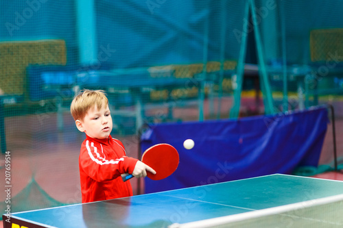 child plays table tennis in the gym photo