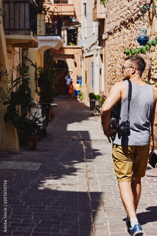 Young man traveller with camera and cell phone exploring the foreign city  Chania, Creta, Greece Stock Photo | Adobe Stock