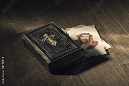 Sacred bible and Holy card with Jesus Christ image on a desk