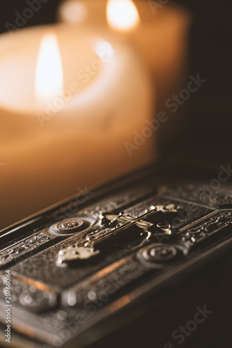 Precious old Bible and lit candles in the Church