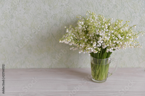flowers lily of the valley stand on the table background © OlgaChan