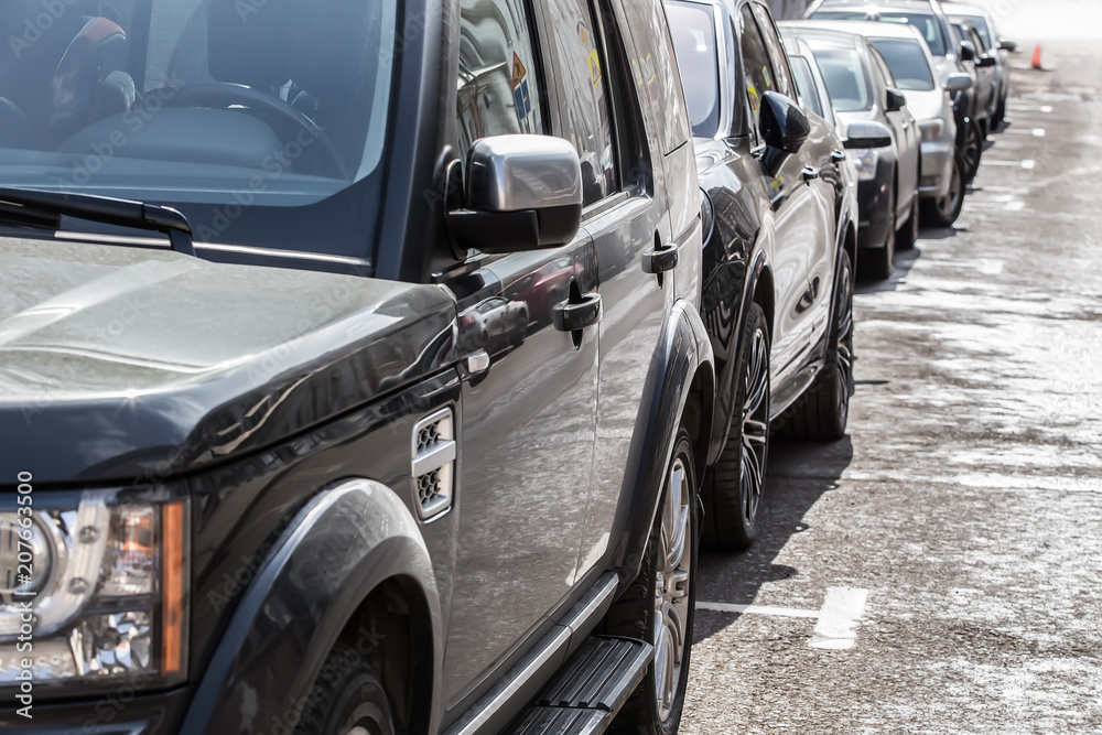 Several cars are parked in row in the parking lot. Several cars are parked in row in the parking lot.