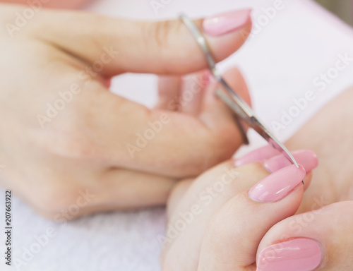 Nail scissors in a woman s hand. Close-up  selective focus.