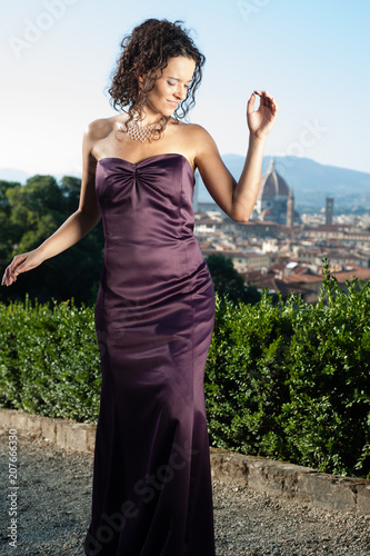 Young brunette girl acting as a robot. Sunny day, Florence Italy