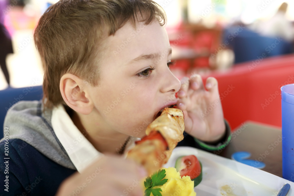 Child eating chiken kebab