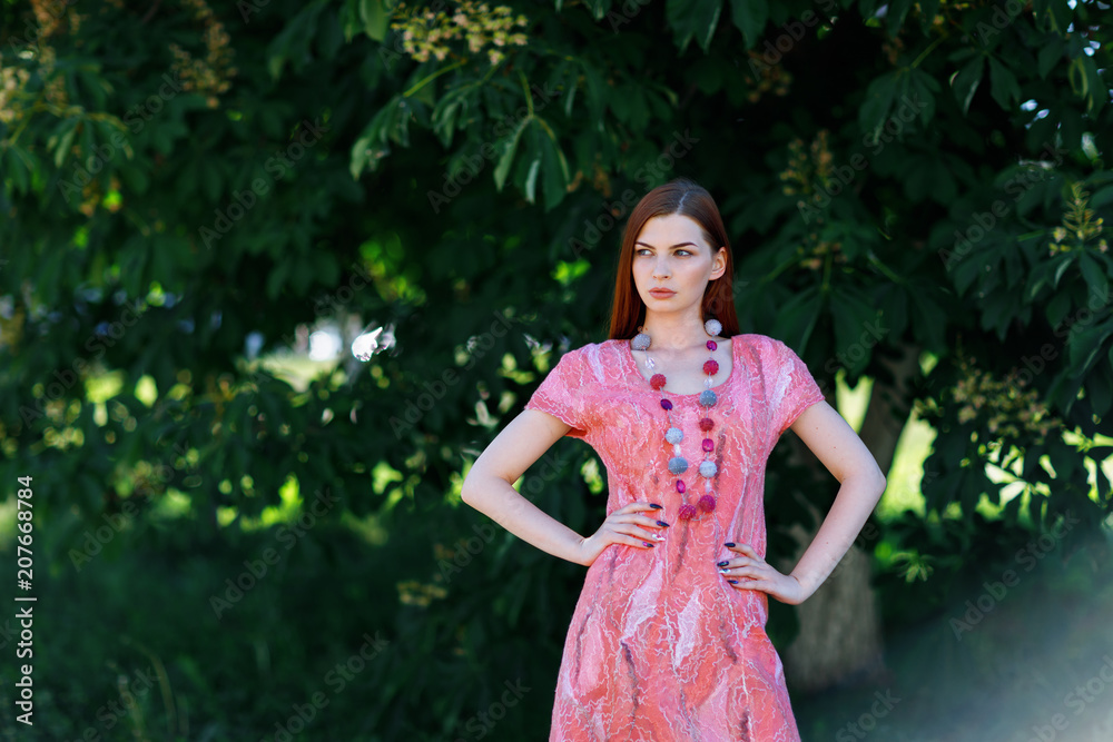 Young beautiful girl posing in seamless dress made in author's technique from merino wool with space for text. Model shows designer clothes Young beautiful girl posing in seamless dress made in author's technique from merino wool with space for text. Model shows designer clothes