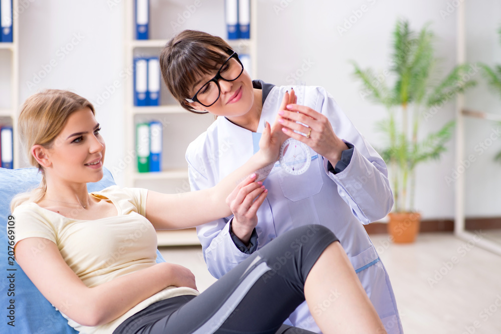 Doctor checking joint flexibility with goniometer Doctor checking joint flexibility with goniometer
