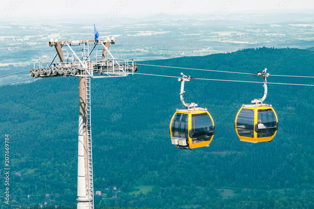 Fototapeta premium the funicular descends to the foot of the mountain in the Polish mountains, the funicular opposite the blue sky in the mountains, a trip to the mountains
