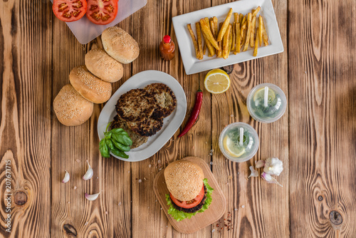 Tasty hamburger with meat and vegetables against a dark background. Fast food. It can be used as a background