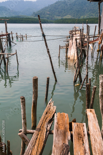 Broken pier of wooden planks in the Thai fishing village.