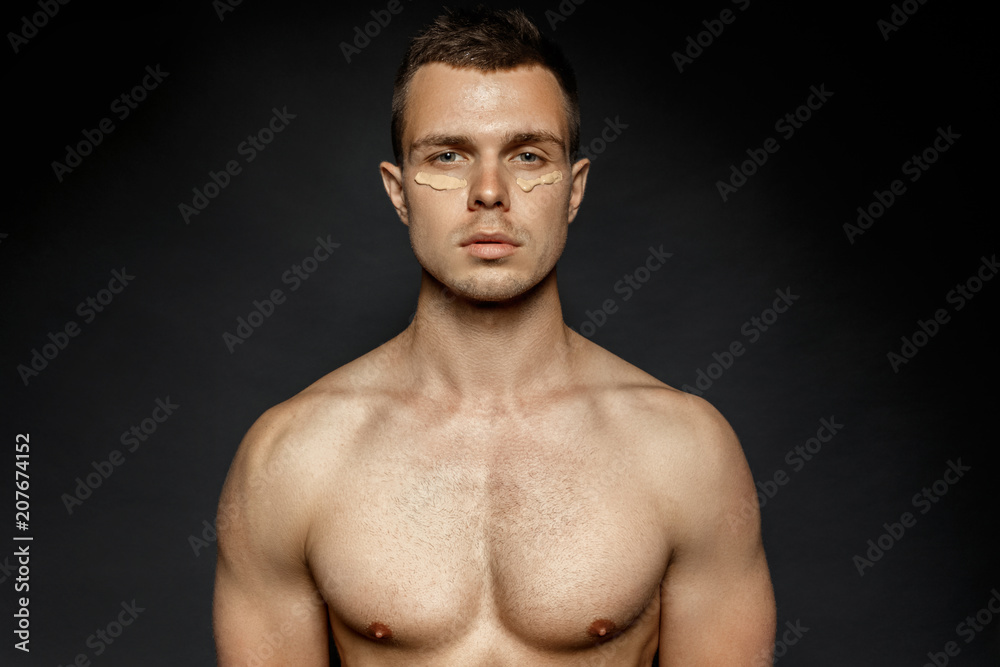 Male portrait with cosmetic foundation makeup on black background Male portrait with cosmetic foundation makeup on black background