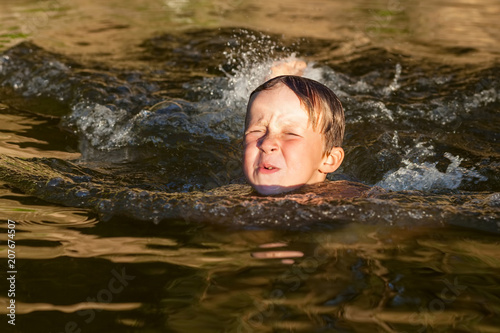 Fototapeta Naklejka Na Ścianę i Meble -  Little boy swimming in the river