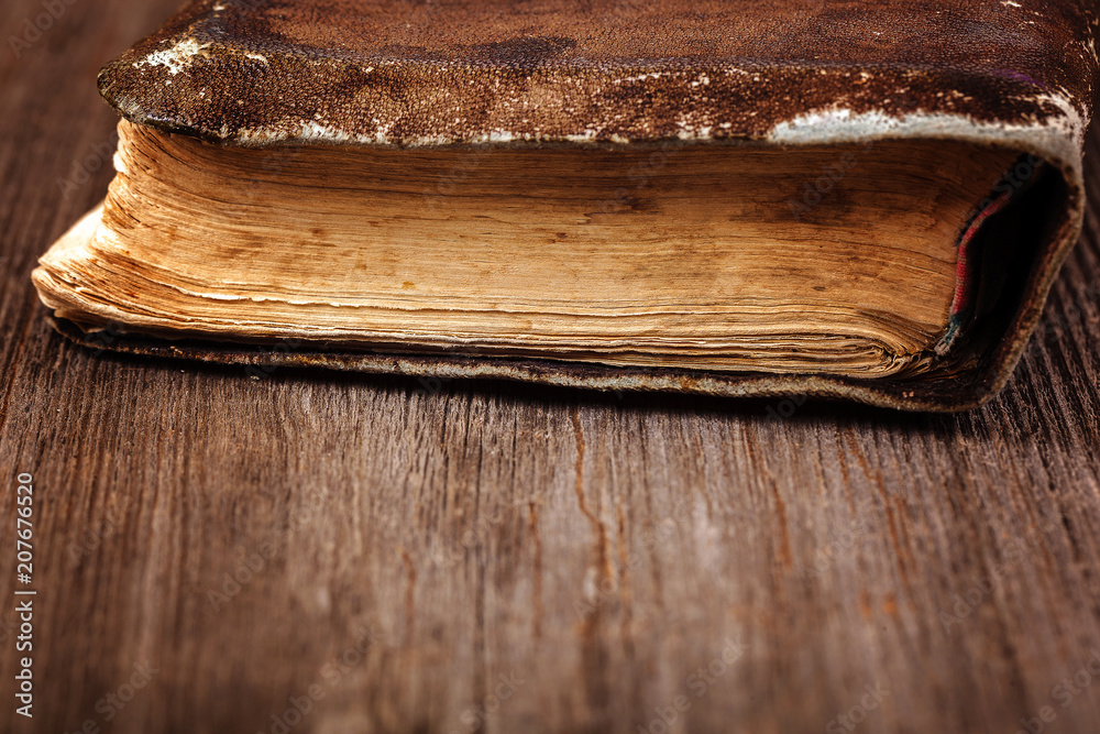 Ancient holy book on a cord on a wooden background