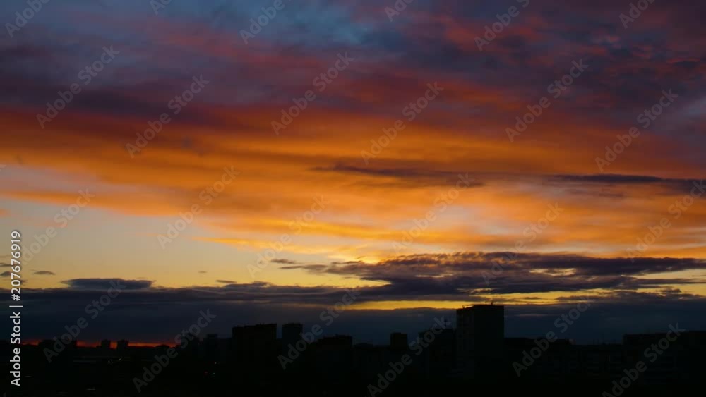 Time lapse of orange sunset. Dark blue clouds floats by golden sky Time lapse of orange sunset. Dark blue clouds floats by golden sky