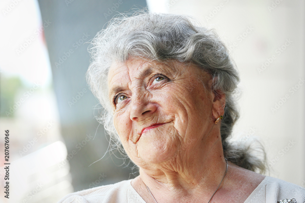 Thoughtful elderly woman portrait on a light background Thoughtful elderly woman portrait on a light background