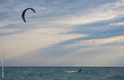 kitesurfer rides a kite-surf on waves of the sea