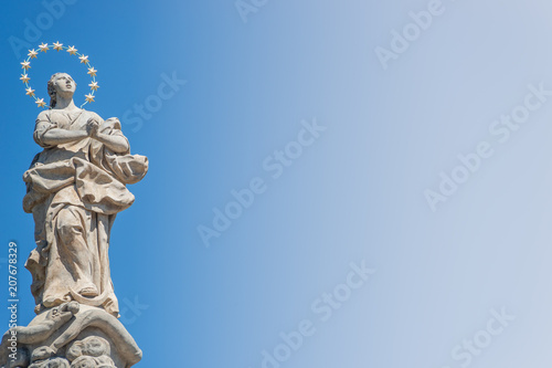 Statue of praying lady at Marian Column or Holy Trinity at Hradcanske Square for bubonic plague epidemics in Prague, Czech Republic