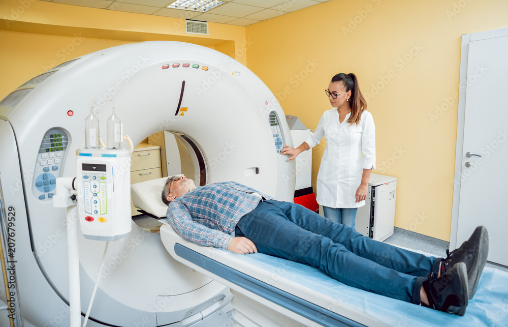 Doctor and patient in the room of computed tomography at hospital. Doctor and patient in the room of computed tomography at hospital.